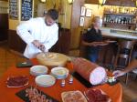 Chef cutting the piece of Parmesan 20 kilograms.